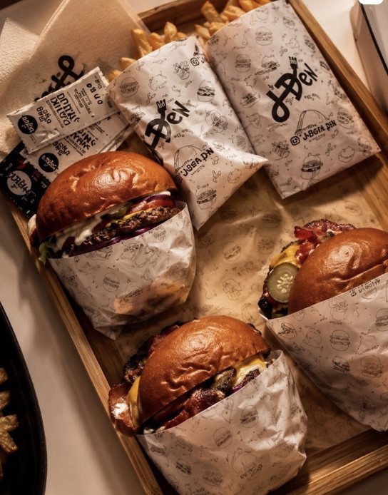 A tray of J'DEN smash burgers with fries